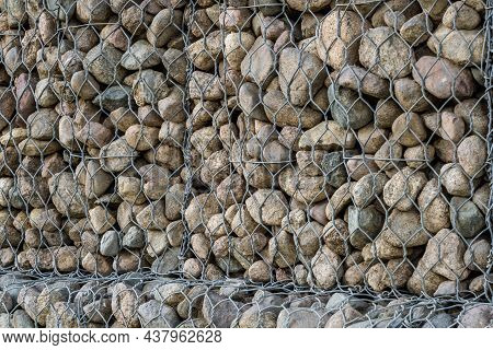 Engineering Structure Made Of Stones Behind Metal Wire Netting To Strengthen The River Bank Near The
