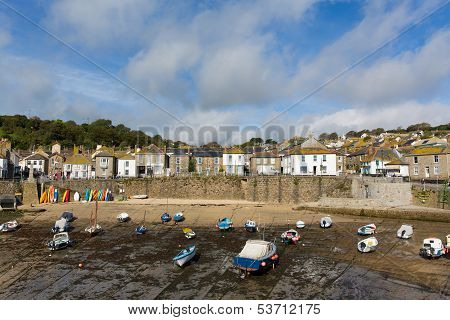 Boats at low tide Mousehole harbour Cornwall England UK