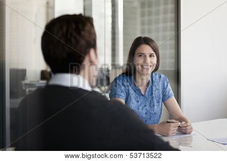 Two business people sitting at conference table and discussing during business meeting