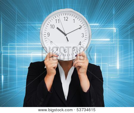 Composite image of businesswoman in suit holding a clock 