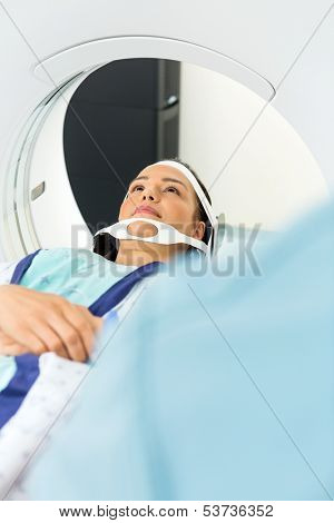 Young female patient undergoing CT scan in examination room