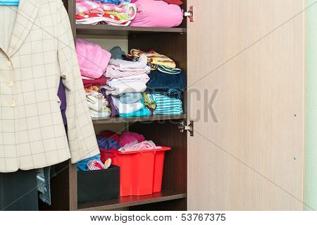 Various Color Clothes Are Organized At Shelves In Open Wardrobe