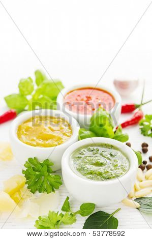 Assortment of three colorful hot sauces with ingredients