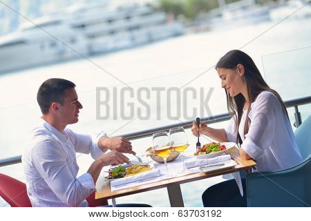 happy young couple having lanch at beautiful restaurant on by the sea on  beach