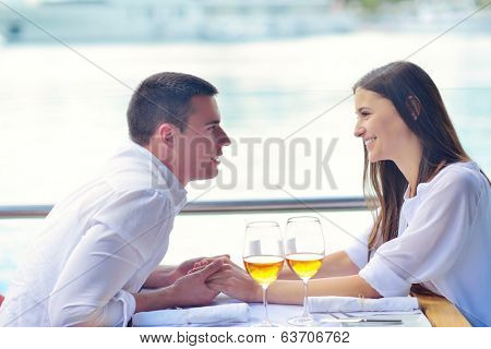 happy young couple having lanch at beautiful restaurant on by the sea on  beach