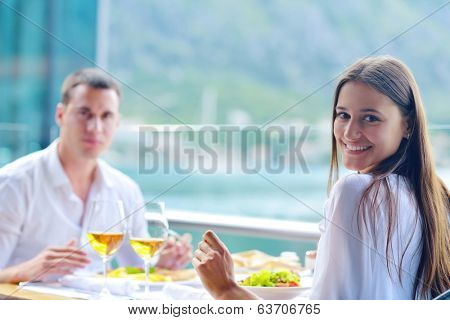 happy young couple having lanch at beautiful restaurant on by the sea on  beach