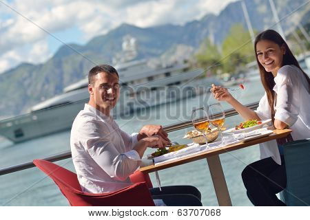 happy young couple having lanch at beautiful restaurant on by the sea on  beach