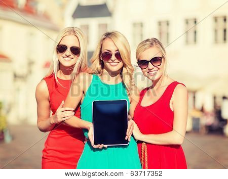 holidays and tourism concept - beautiful blonde girls toursits showing tablet pc with blank screen in the city