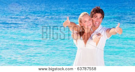 Happy couple on the beach, young family in love spending honeymoon vacation on luxury islands, cheerful active young people having fun at summertime travels, joy of life concept