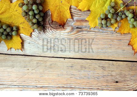 Marple Leaves And Grapes On Wooden Texture