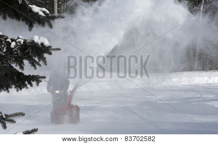 Man cleaning snow with blowing machine