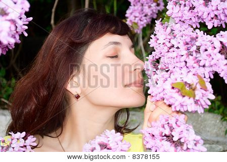 Žena Sniffs Redbud květiny