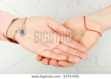 Two hands of friendship and religions symbols