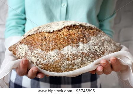 Woman holding tasty fresh bread, close up