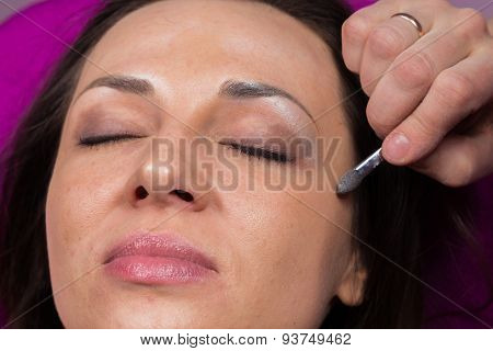 Work of make-up artist. Makeup artist apply makeup on the face of the girl model.