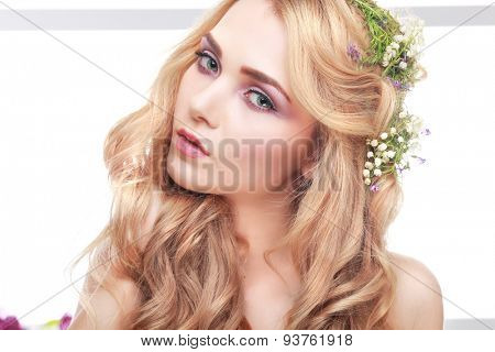 Beautiful girl, isolated on a light - grey background with varicoloured flowers in hairs, emotions, cosmetics