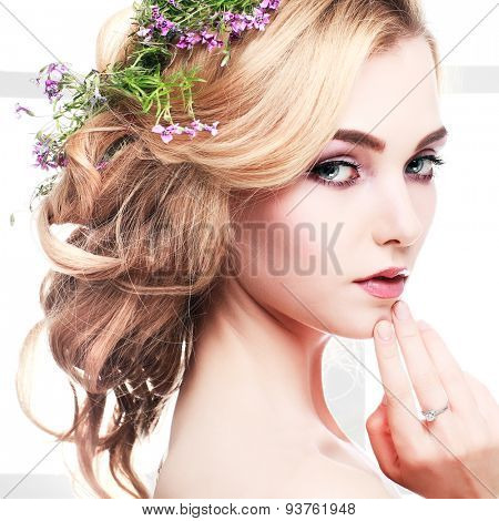 Beautiful girl, isolated on a light - grey background with varicoloured flowers in hairs, emotions, cosmetics