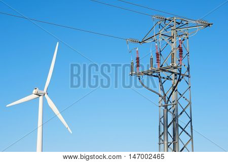Windmill for electric power production and pylon, La Muela, Zaragoza Province, Aragon, Spain.
