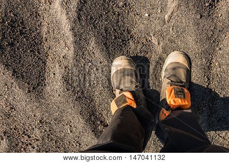 Overhead photo of feet on a background of brown sand. Man feets. Exploring travelling tourism adventure.
