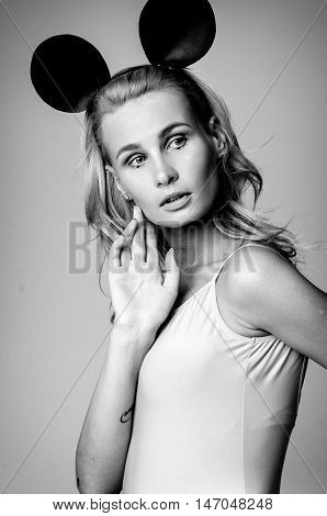 Blonde girl wearing bodysuit and black mouse ears, black and white photo