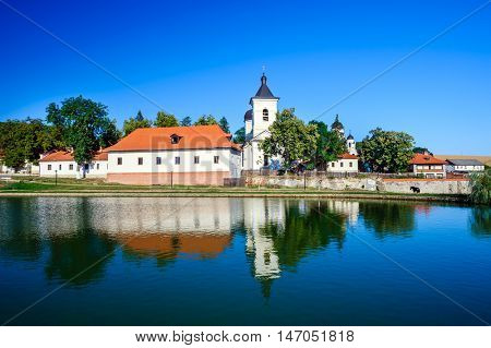 Rustic landscape with pond near the walls of Capriana Orthodox Christian Monastery, one of the oldest monasteries of Moldova, first time mentioned in 1429.