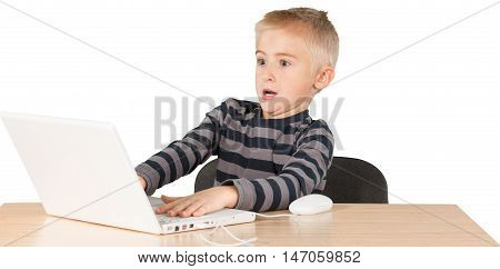 Young boy palying game on a latop and leaning way back