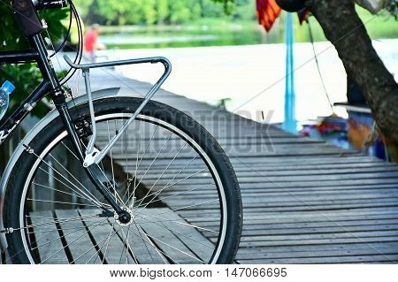 The Black bicycle on a wooden bridge in riverside.