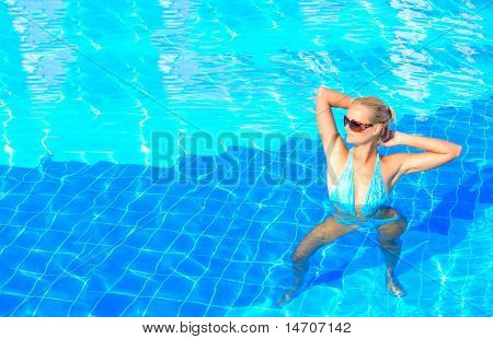 Beautiful young woman at a pool in Greece
