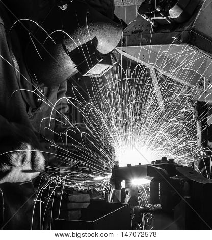 welder welding Industrial automotive part in factory (black white )
