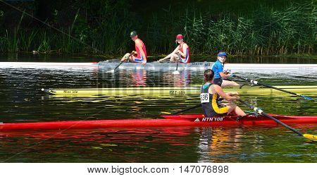 St Neots, Cambridgeshire, England - July 24, 2016: Rowers and colorful boats on the River Ouse at St Neots Cambridgeshire.