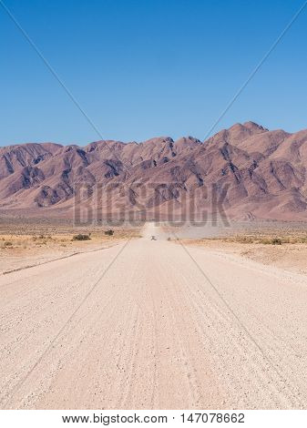 Typical gravel road in Namibia, mountains in the background