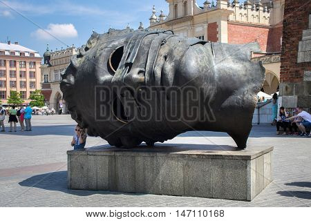 POLAND, KRAKOW - MAY 27, 2016: Krakow is the second largest and one of the oldest cities in Poland. Head sculpture Eros Bendato on Market Square.