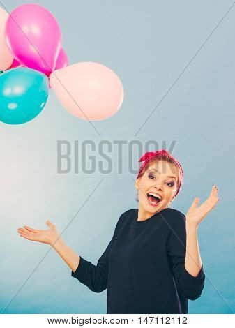 Craziness and lots of fun. Cute crazy joyful girl playing with colored balloons. Blonde playful retro style woman feel craze.