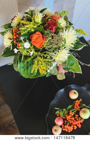 bouquet of apple Chrysanthemum rowan stonecrop anisetree phlox near edible ingredients on plate