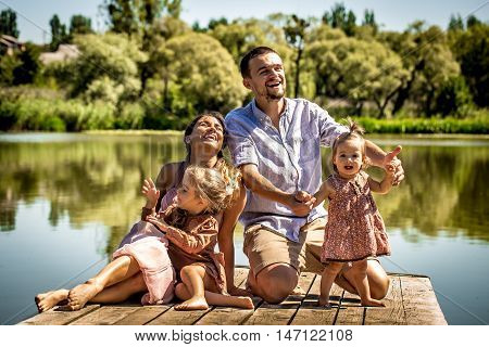 Young Family On Pier Near Lake