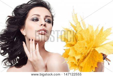 closeup beauty portrait of attractive  caucasian  woman brunette isolated on white studio shot lips  face hair head and shoulders hand holding yellow marple autumn leaves