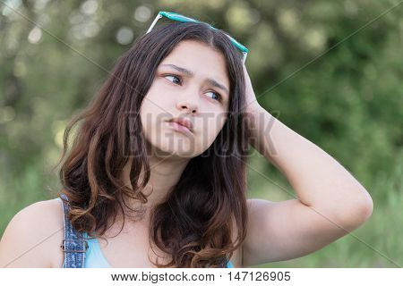 Portrait of a sad teen girl on nature