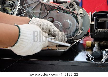 Hands of disassembly kit motorcycle in repair service. Automotive engine disassembly kit motorcycle.