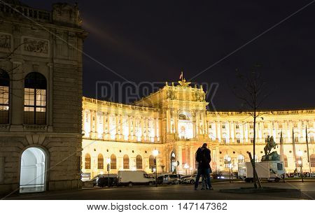 VIENNA, AUSTRIA - NOVEMBER 13, 2015: A young couple in front of Hofburg Palace on heldenplatz at night