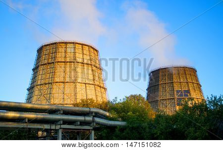 two large pipes with smoke thermal power plant sunrise sunset