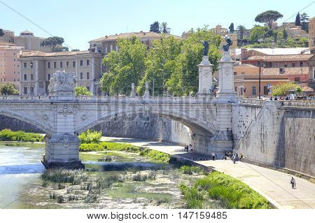 Old stone bridge of Vittorio Emanuele II across the river Tiber in the historical center of city Rome