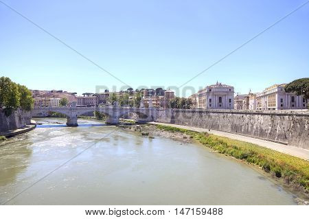 Old stone bridge of Vittorio Emanuele II across the river Tiber in the historical center of city Rome
