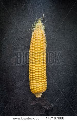 Peeled corn ear on a gray slate