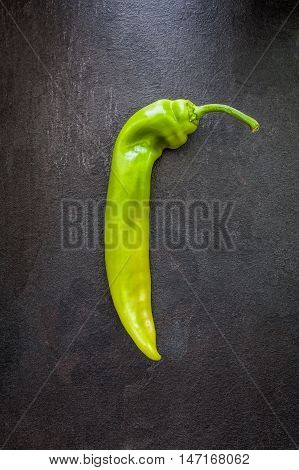 Green whole pepper on a grey slate