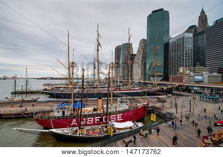 New York City USA - November 15 2011: People walk in Landmark seaport located next to Wall Street and financial center in nasty weather at November 15 2011 NYC. The port is a designated historic district containing the largest concentration of 19th centur