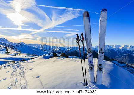 Ski in winter season, mountains and ski touring equipments on the top at sunrise.
