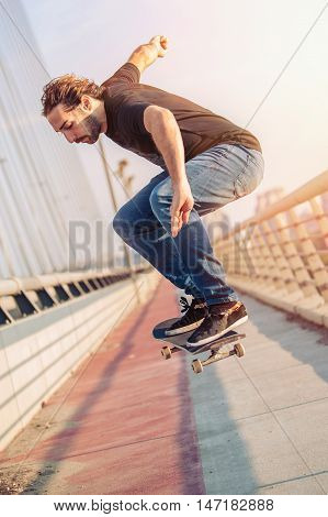 Skateboarder Skates And Doing Jumps Over A City Bridge. Free Ride Street Skateboarding