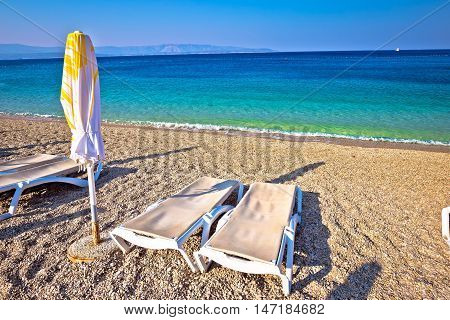 Idyllic turquoise beach parasol and deck chair Zlatni Rat Bol Croatia