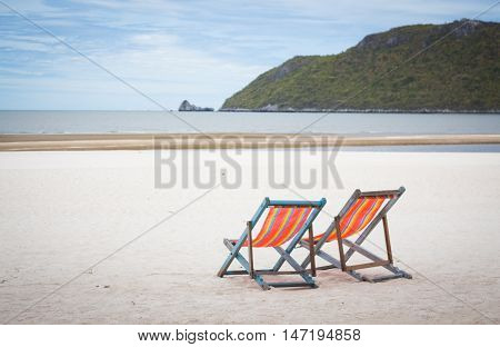 rainbow summer two beach chairs for relax on the beach in vacation time