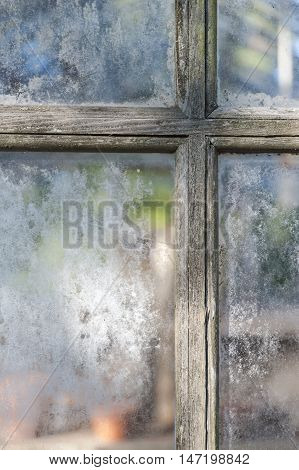 Weathered muntins and window panes on aging greenhouse